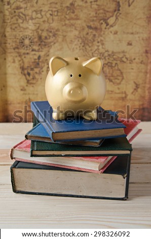 Gold Piggy bank stand on top of book
