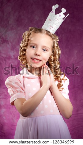 Little princess posing over dark pink background