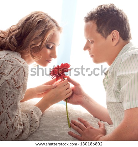 beautiful young couple. Man presents flower