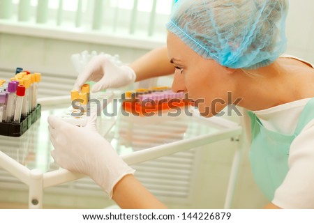 Medical doctor woman looking on test tube with blood