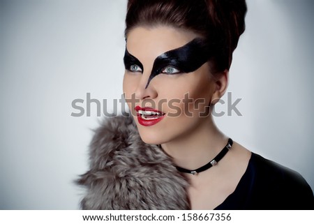Portrait of a beautiful female model with cat makeup and fur