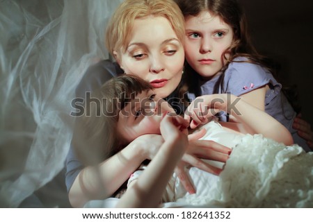 mother and daughter in bed. Mother  calms distressed daughter