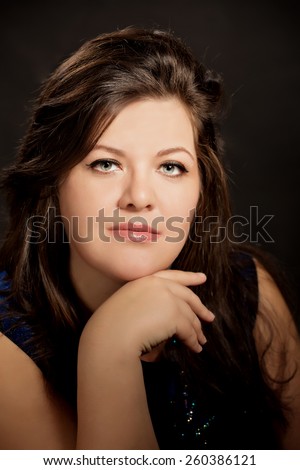 beautiful plus size  brunette  woman  playing with colorful beads over dark background