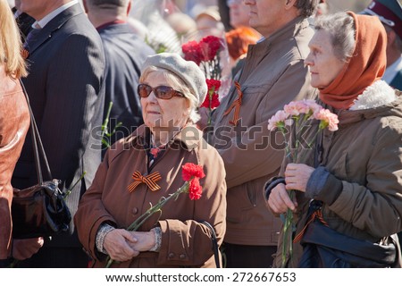 Saint Petersburg /RUSSIA - MAY 9: Old  woman veteran of  WWII  decorated with  medals and soldiers  during festivities devoted to anniversary of Victory Day on May 9, 2013 in Saint- Petersburg