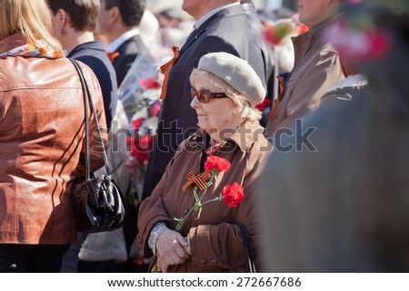 Saint Petersburg /RUSSIA - MAY 9: Old  woman veteran of  WWII  decorated with  medals and soldiers  during festivities devoted to anniversary of Victory Day on May 9, 2013 in Saint- Petersburg