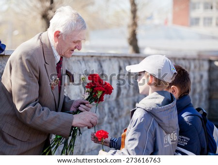 Saint Petersburg /RUSSIA - MAY 9: Old   veterans of  WWII   during festivities devoted to anniversary of Victory Day on May 9, 2013 in Saint- Petersburg. children handed flowers to the veteran