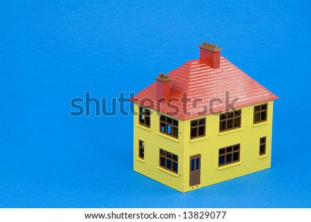 toy house on blue background - blueprint concept with copy space