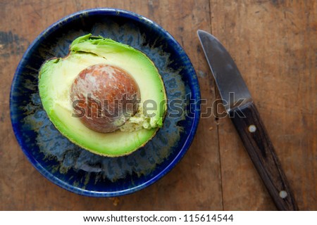 avocado on a old table with old fruit knife.