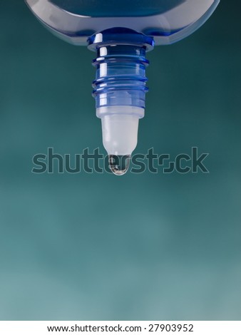 Droplet of eye drop in blue container.