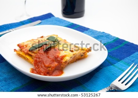 lasagna on white plate and blue table mat