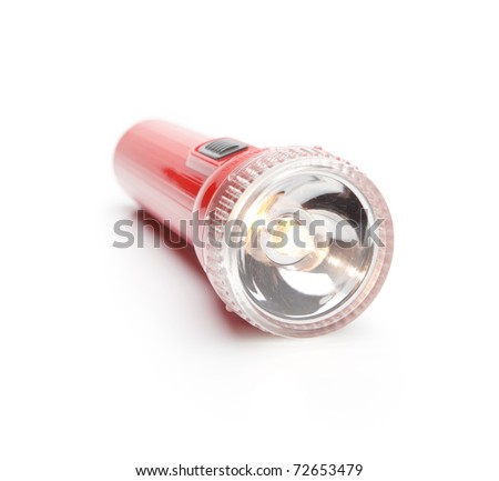 Red torch type flashlight with lighted bulb. Isolated on white with natural shadow.
