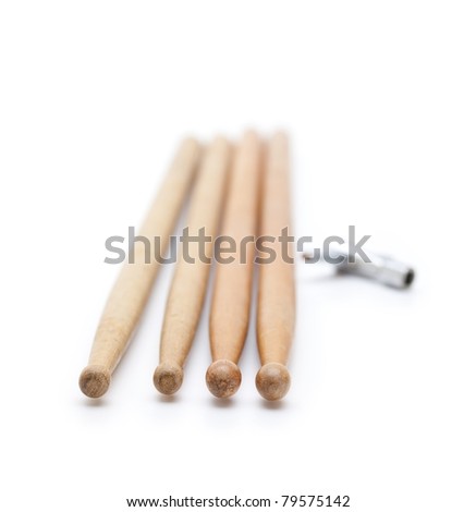Drum stick in real world condition , and common drum tuning key isolated on white.