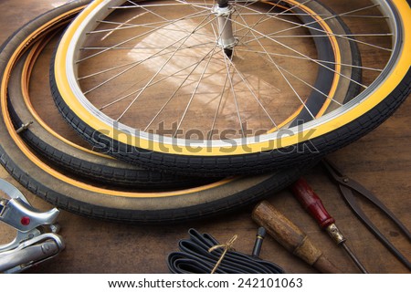 Bicycle repair. Repairing or changing a tire or wheel of an vintage bicycle. Old bicycle wheels on a grungy work desk with well used tools and bicycle parts.