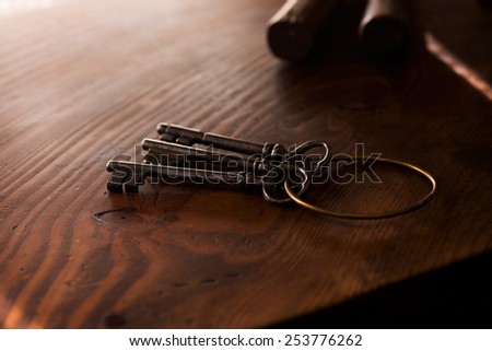 Vintage keys on an grungy old desk in light and shadow. Shallow depth of focus.