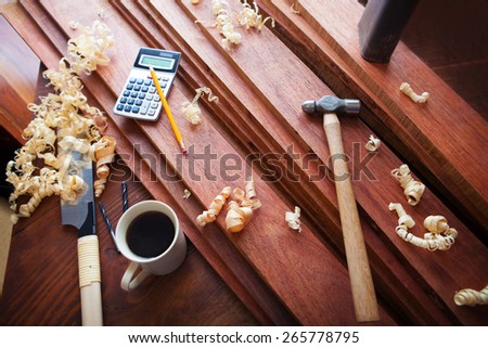 Wood working or carpentry scene with coffee. High quality hard wood lumber and wood working tools and coffee on a work bench.