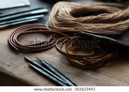 leather craft or leather goods making. work bench of a leather smith. Shallow depth of field.