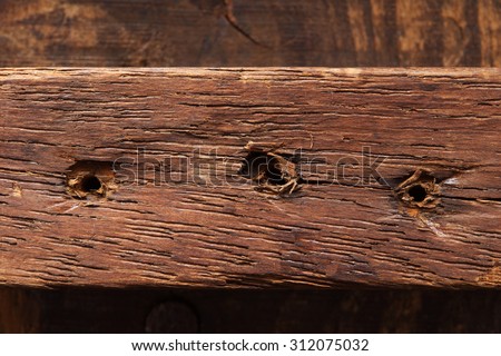 Old grungy wood part with old nail holes (nails pulled out).