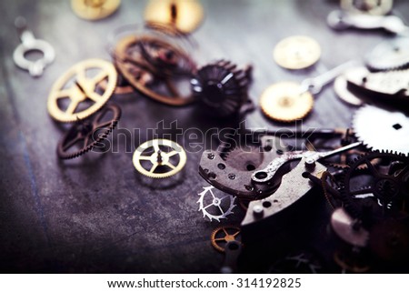 Clock parts scattered. Intentionally shot in muted vintage tone, with extremly shallow depth of field.
