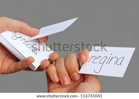 teenage girls hands, holding file cards with latin vocabulary, learning for school