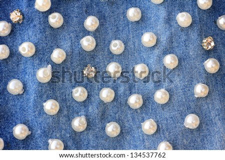 stitched pearls on a blue Jeans denim, Fashion background