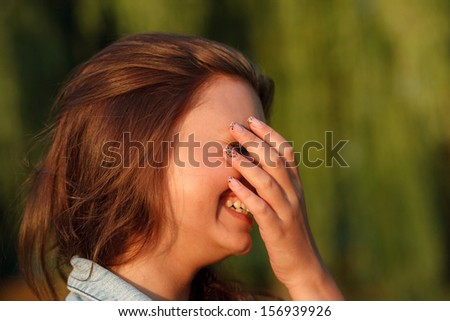close-up portrait of shy teenage girl hiding her face with hand