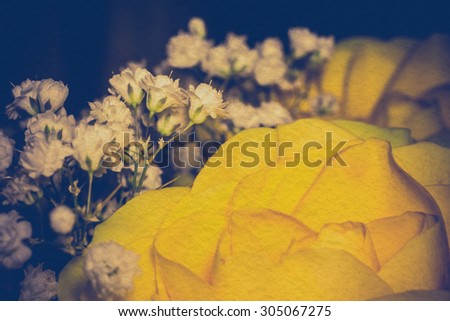Bright yellow rose in a bouquet, shallow focus, vintage photo effect with paper texture.