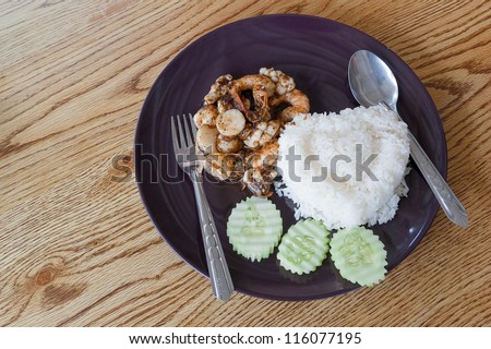 Thai food, fried shrimps and fish ball with steam rice on table