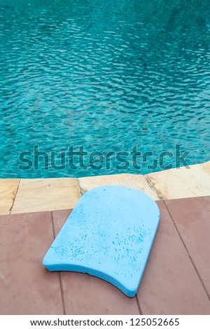 Blue foam board for the teaching of swimming beside swimming pool