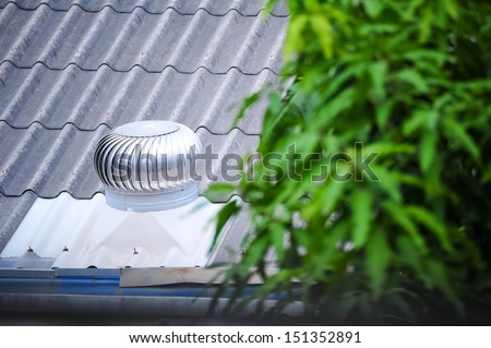 air vent on the old roof with blurred plant foreground