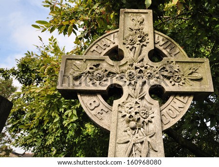 Old decorated memorial stone Celtic cross in London cemetery