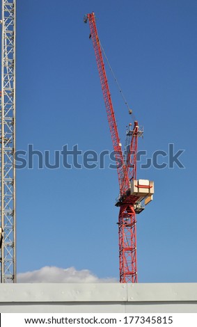 Red building construction crane in London.