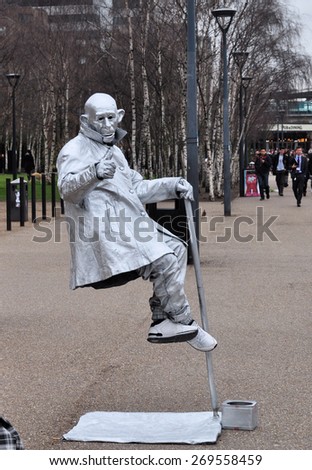 LONDON - MARCH 28, 2015. A street entertainer apparently defies gravity near the Tate Modern art gallery, a popular tourist venue by the River Thames in central London, UK.