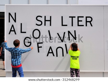 MARGATE, KENT, UK - AUGUST 15. 2015. Chldren rearrange the lettering on an installation at the Turner Contemporary art gallery located at the coastal town of Margate, Kent, UK.