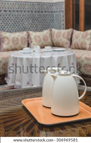 Two white jugs on the wooden table in Moroccan house prepared for breakfast in Fes, Morocco