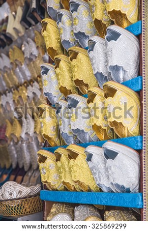 The gold and silver traditional shoes of Morocco made from cloth for bride sell in the Medina in Fes, Morocco
