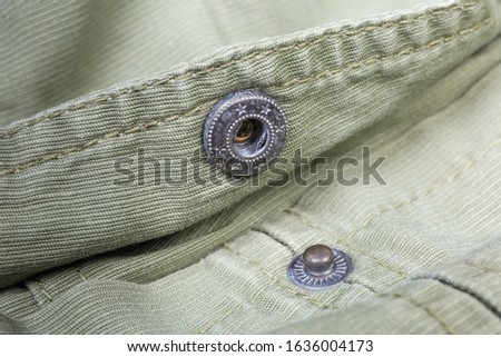 Unbuttoned metal snap button fastener mounted on the outerwear olive color close-up at shallow depth of field ストックフォト © 