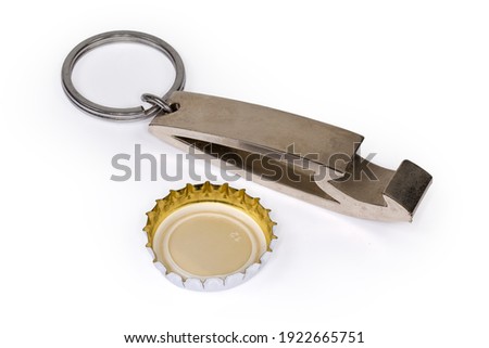 Metal bottle opener in the form of a keychain with attached steel split ring and inverted used metal crown bottle cap with plastic backing close-up on a white background ストックフォト © 
