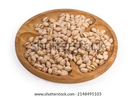 Roasted salted pistachio nuts with partly open shells on a wooden compartmental dish on a white background 商業照片 © 