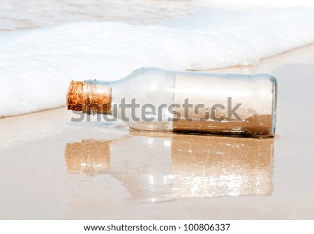 Blank brown paper in a glass bottle on the beach.