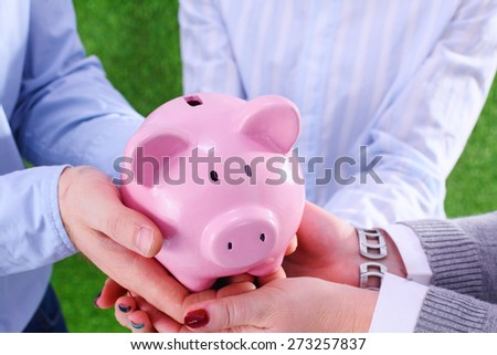 Businesswoman and man holding a piggy bank