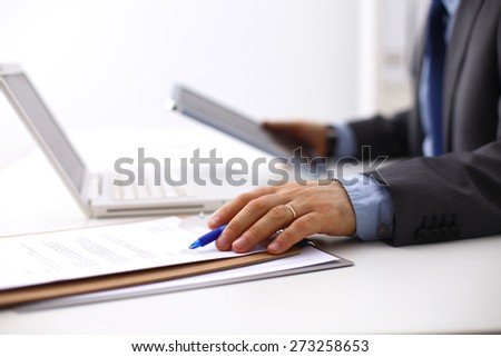 Businessman sitting in office, working with laptop computer