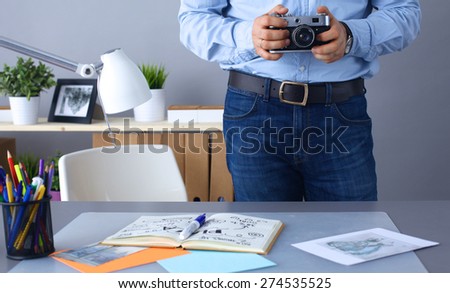 Photographer processing pictures standing at the desk