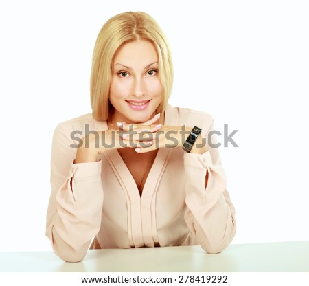 Portrait of a confident  woman with hand on chin sitting at table against white background