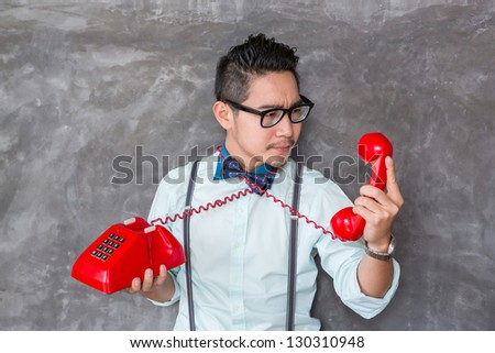 Young man looking the red telephone with bad felling face