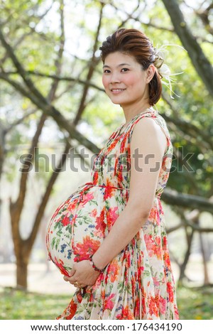 Beautiful asian pregnant woman portrait in public park - photo taken 2 days before baby birth