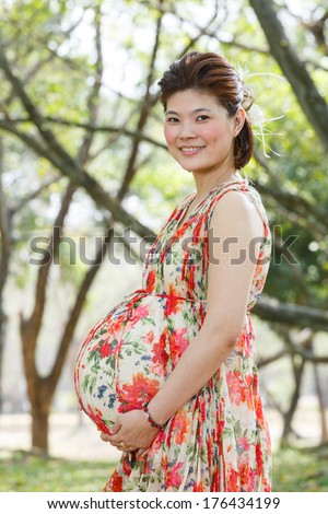 Beautiful asian pregnant woman portrait in public park - photo taken 2 days before baby birth