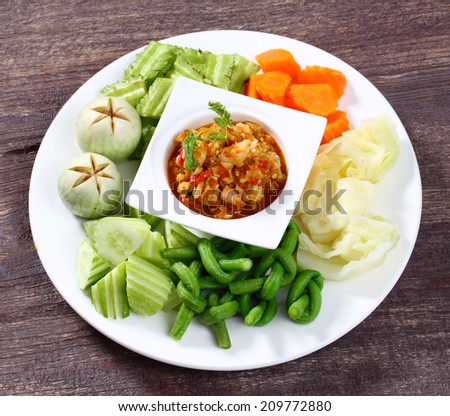 Close up spicy shrimp dip sauce served with raw and boiled vegetable