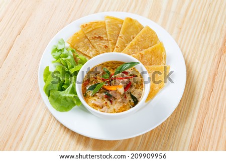 Close up Indian pancake served with chicken curry and green oak lettuce