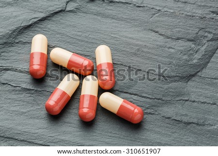 Close up medicine capsule or tablet black color stone, medical and health care concept