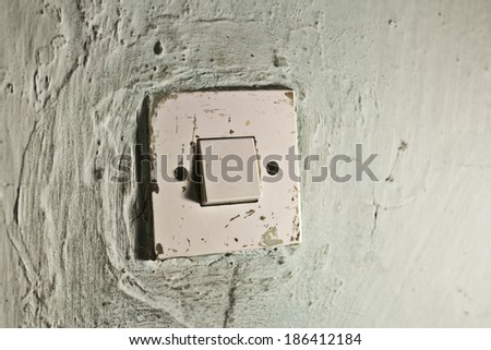 Old light switch on old cracked green wall